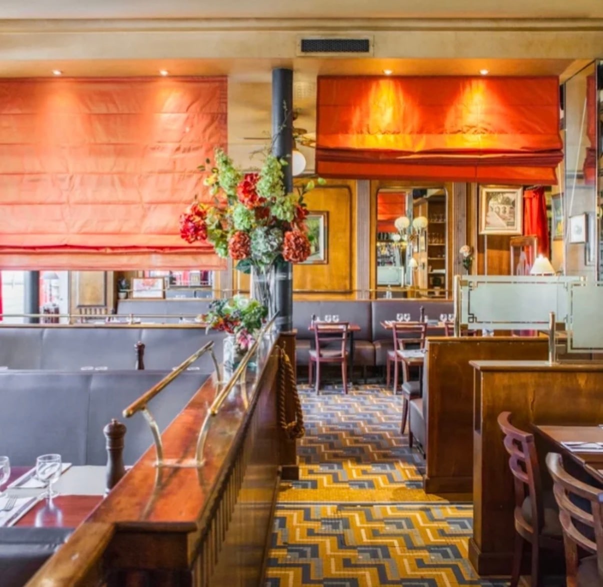 Le Sully's dining room: banquettes, wood panelling, orange blinds and mosaic floor
