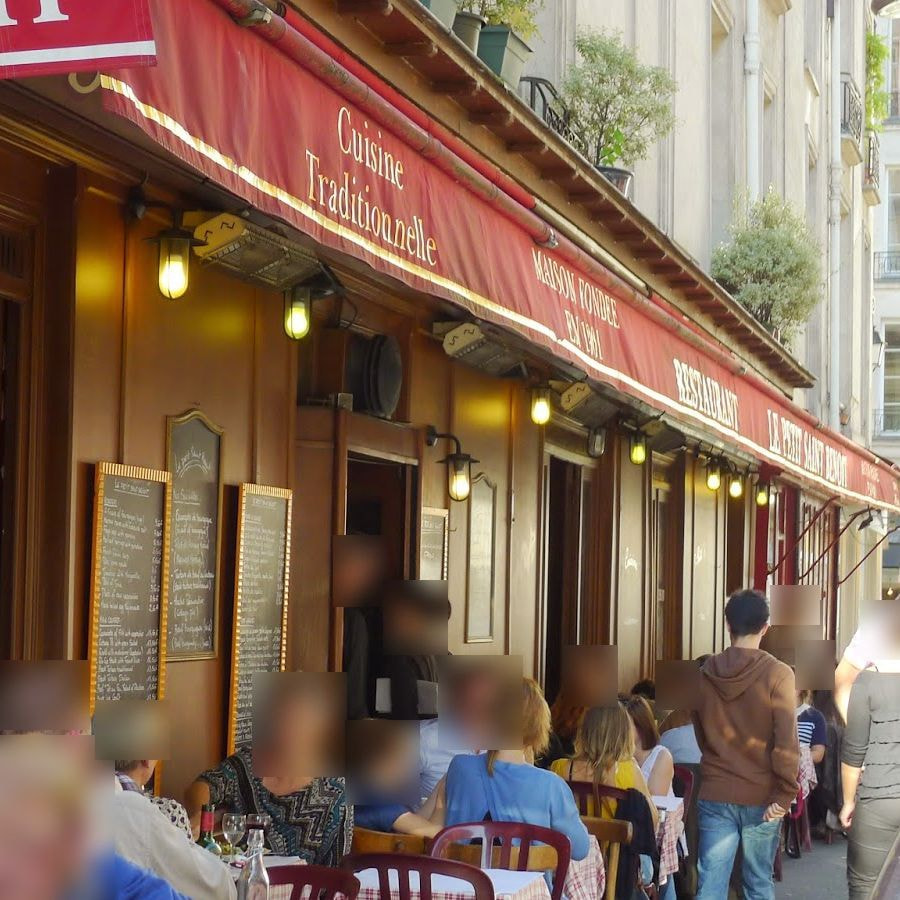 Le Petit Saint-Benoît's terrace under its red 'Cuisine traditionnelle' awning on rue Saint-Benoît